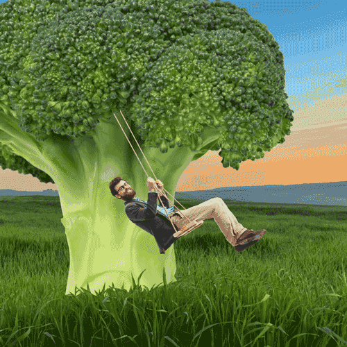 Un homme faisant de la balançoire sous un brocoli géant